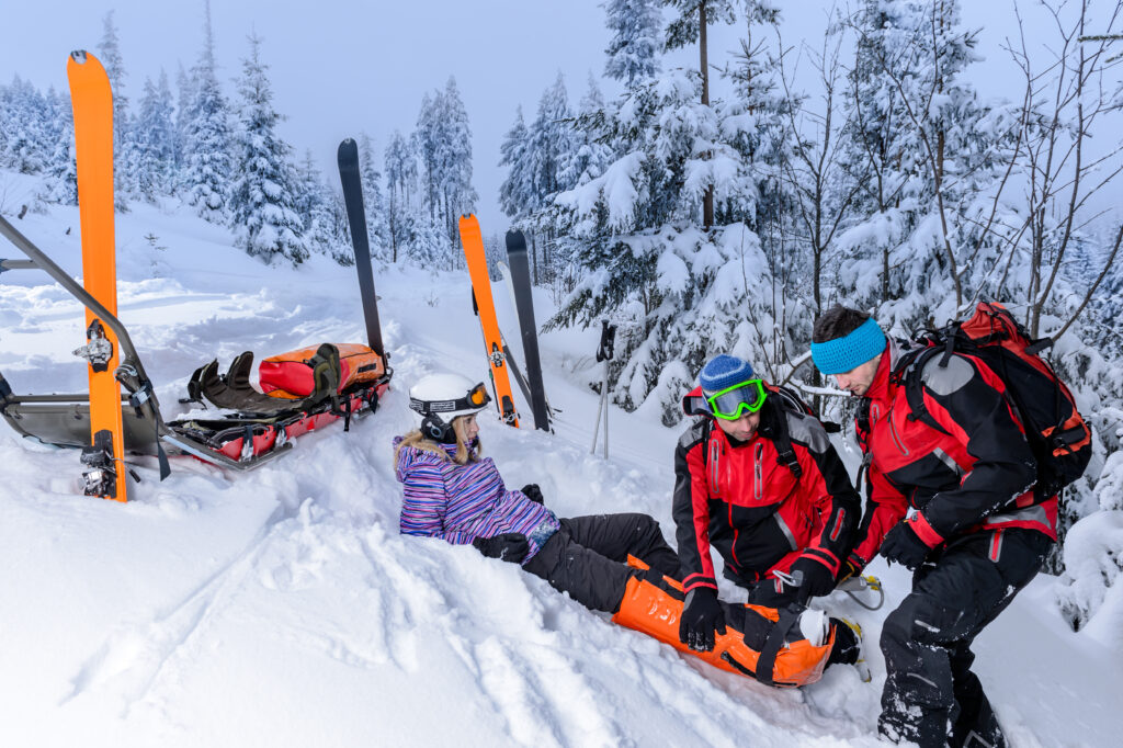 Ein Rettungsteam rettet eine Skifahrerin mit gebrochenem Bein