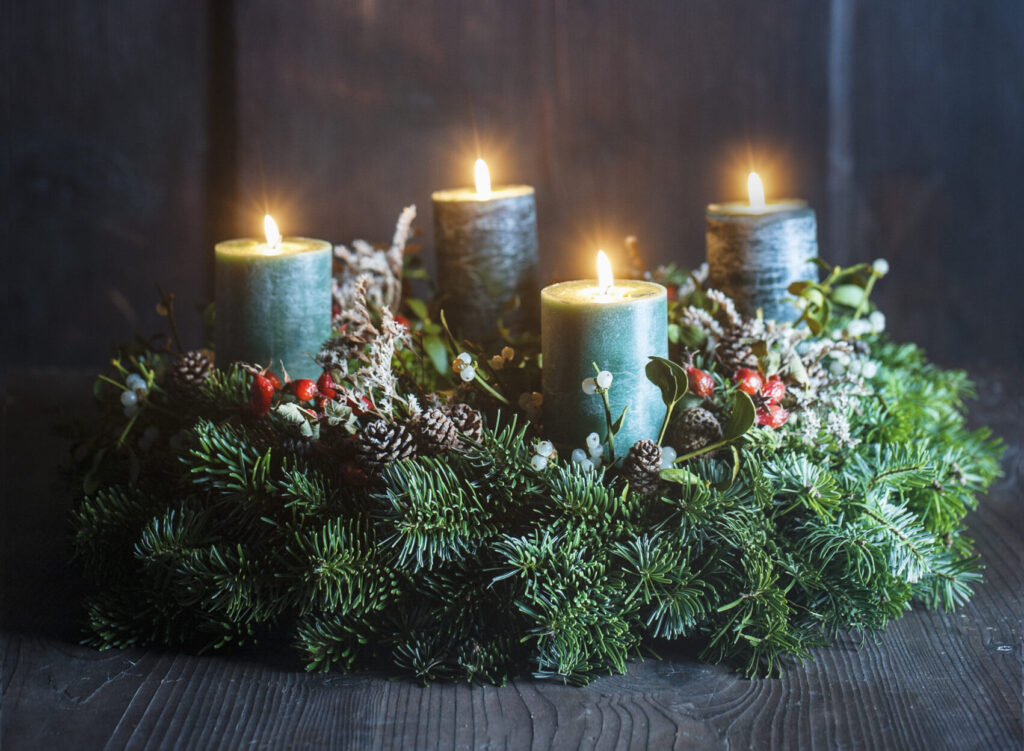 Adventskranz auf Holztisch vor alter Bauernstubenwand