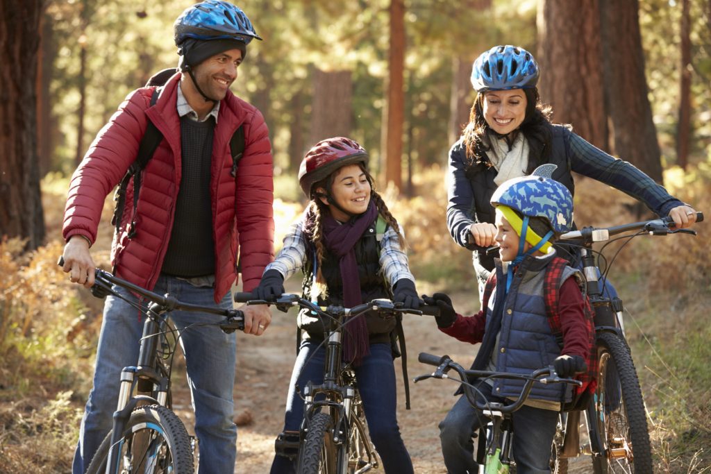 Glückliche Familie fährt mit ihren Fahrrädern durch den Wald, was passiert im Todesfall.