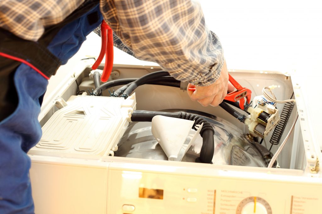 Klempner repariert ein Elektrogerät dessen Garantie abgelaufen ist