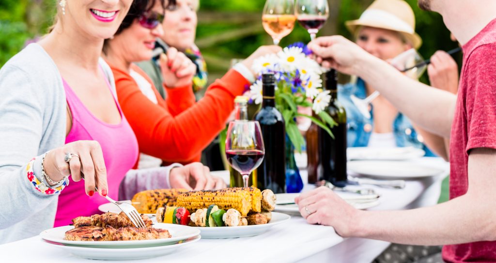 Männer und Frauen feiern auf Gartenparty